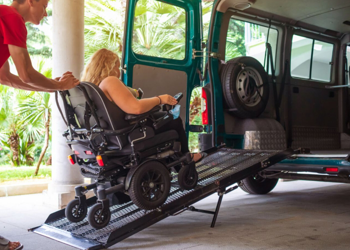 Person in wheelchair using ramp to enter an accessible transport van - NDIS travel and transport