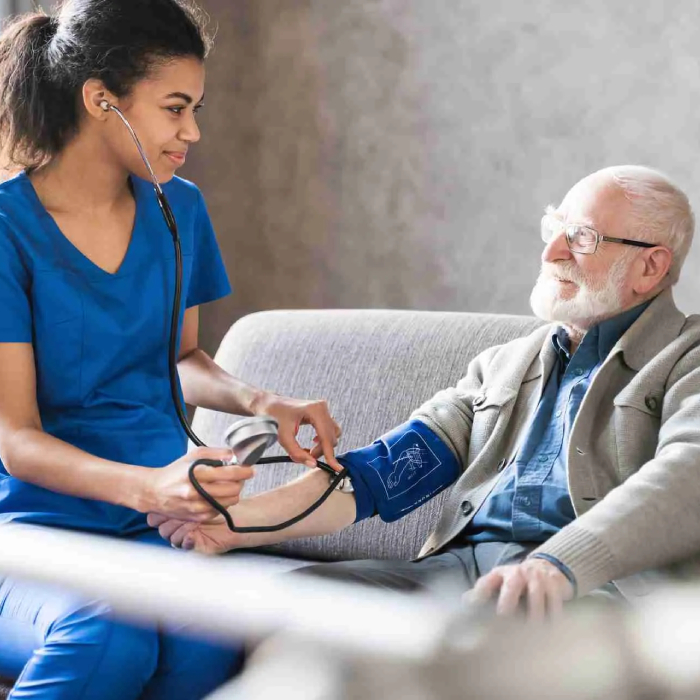 Homecare nursing - Nurse checking elderly man's blood pressure at home