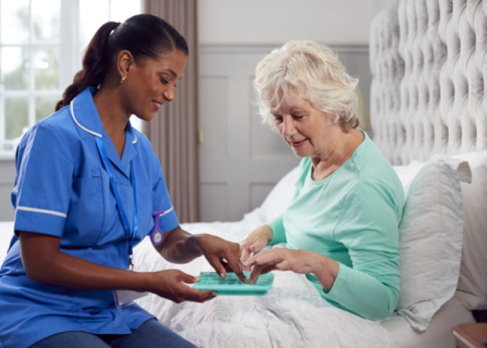Homecare nursing - Nurse assisting elderly woman with medication at home